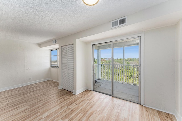 3315 58th Ave S Unit 605, Saint Petersburg, FL 33712 - spare room with wood finished floors, a textured ceiling, plenty of natural light, and baseboards