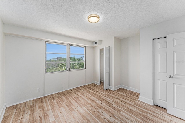 3315 58th Ave S Unit 605, Saint Petersburg, FL 33712 - unfurnished bedroom with light wood-style floors, a textured ceiling, and baseboards