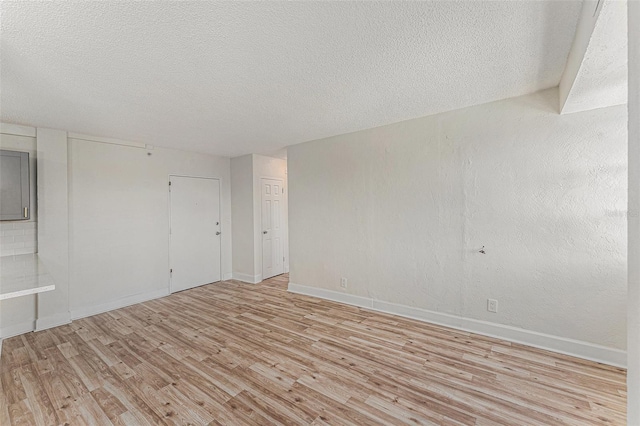 3315 58th Ave S Unit 605, Saint Petersburg, FL 33712 - unfurnished room featuring light wood-style floors, a textured ceiling, and baseboards