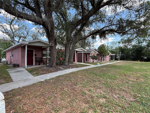 5901 E Gibson Ave, Tampa, FL 33617 - view of front of home featuring brick siding, a front yard, and cooling unit