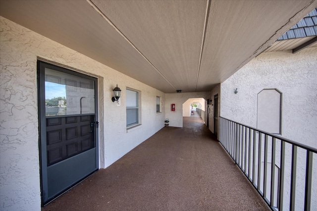view of exterior entry with stucco siding and a balcony