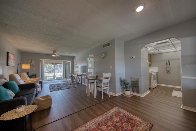 living room featuring wood finished floors, baseboards, and a textured ceiling