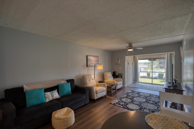 living room with ceiling fan, a textured ceiling, and wood finished floors