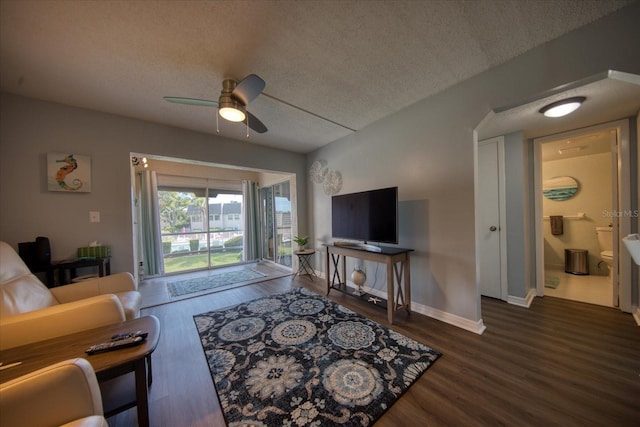 living area featuring a ceiling fan, wood finished floors, a textured ceiling, and baseboards
