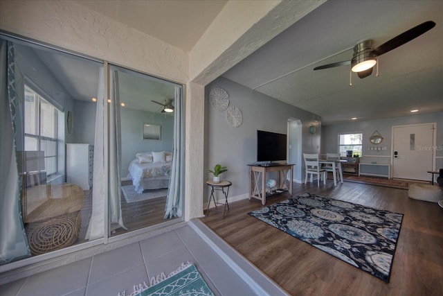 living room featuring a ceiling fan, wood finished floors, and baseboards