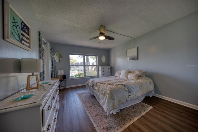 bedroom with a textured ceiling, dark wood-style flooring, baseboards, and ceiling fan