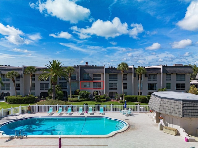 community pool with fence and a patio area