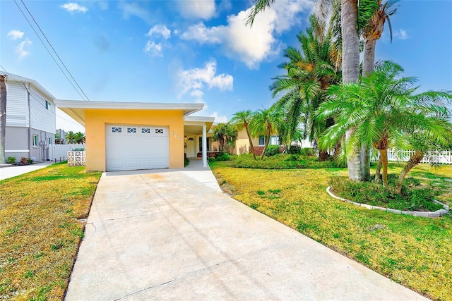 365 La Hacienda Dr, Indian Rocks Beach, FL 33785 - view of front of house featuring stucco siding, a front lawn, driveway, and a garage