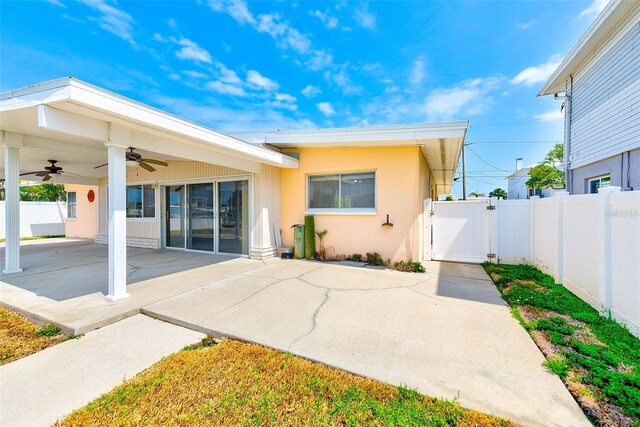 365 La Hacienda Dr, Indian Rocks Beach, FL 33785 - rear view of house with a ceiling fan, a gate, a patio area, fence, and stucco siding