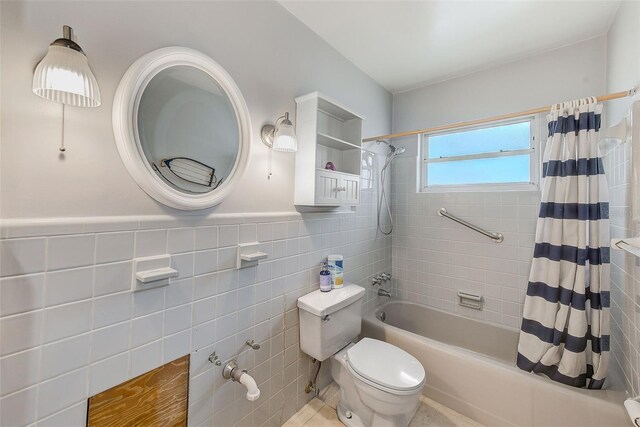 365 La Hacienda Dr, Indian Rocks Beach, FL 33785 - bathroom with tile walls, shower / bathtub combination with curtain, toilet, tile patterned flooring, and a wainscoted wall