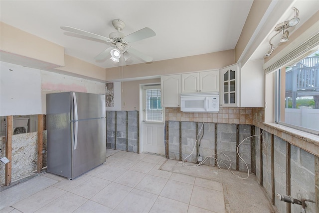 365 La Hacienda Dr, Indian Rocks Beach, FL 33785 - kitchen featuring freestanding refrigerator, white microwave, white cabinets, light tile patterned flooring, and ceiling fan