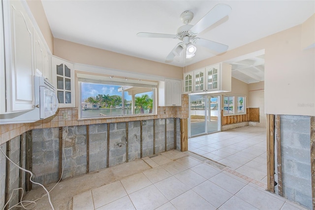 365 La Hacienda Dr, Indian Rocks Beach, FL 33785 - kitchen featuring glass insert cabinets, white cabinetry, light tile patterned floors, and decorative backsplash
