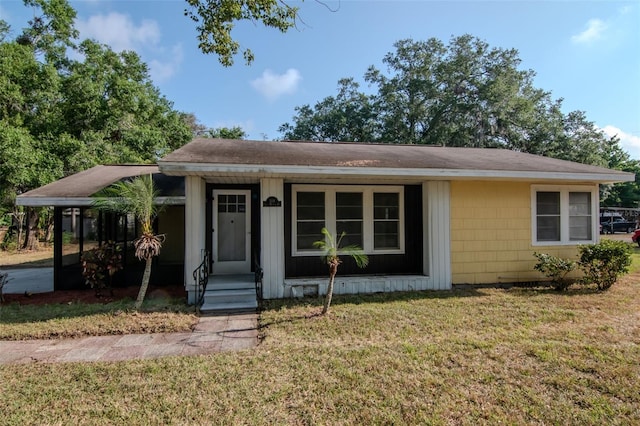 bungalow-style house with a front yard and roof with shingles