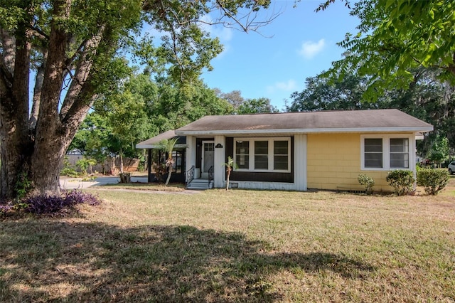 view of front of home with a front yard and roof with shingles