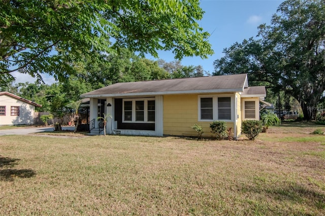 bungalow-style home featuring a front yard and a shingled roof