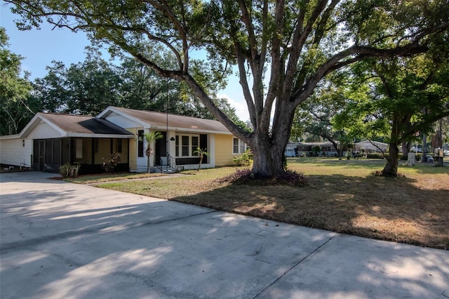 view of front facade featuring concrete driveway and a front yard