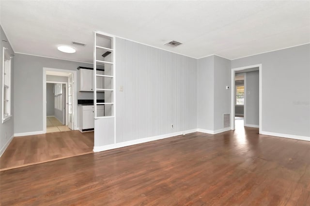 unfurnished living room featuring wood finished floors and baseboards