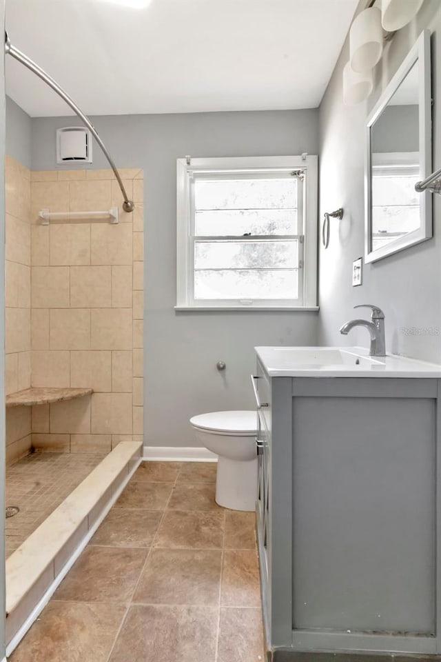 bathroom featuring a shower stall, vanity, toilet, and baseboards
