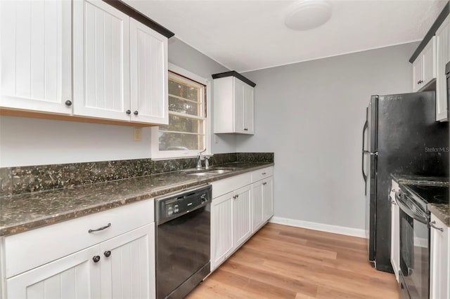 kitchen with black appliances, a sink, light wood-type flooring, dark stone counters, and white cabinets
