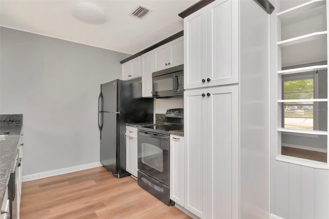 kitchen featuring black appliances, white cabinets, light wood finished floors, dark stone counters, and baseboards