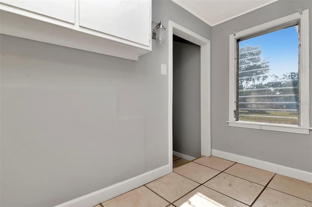 mudroom with plenty of natural light, light tile patterned floors, baseboards, and ornamental molding