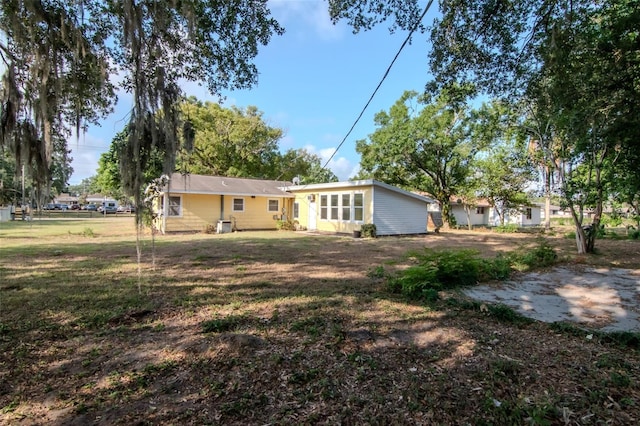back of house featuring a lawn