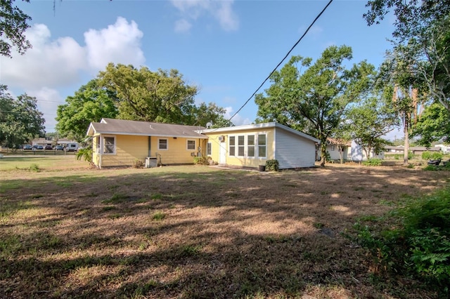 rear view of property with a lawn