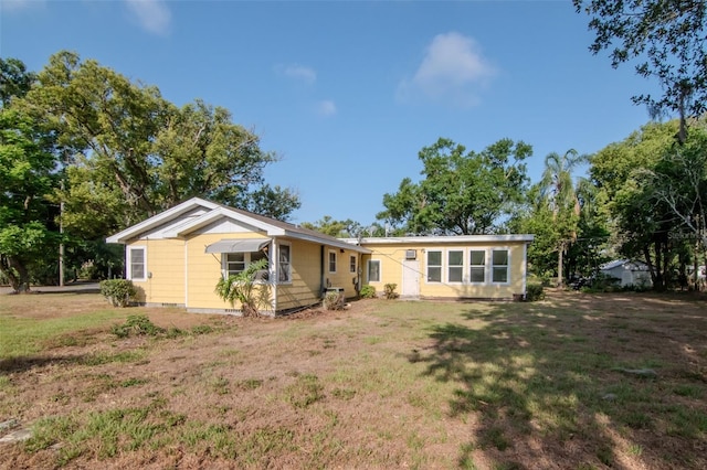 rear view of house featuring a yard