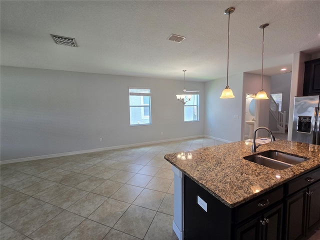 1022 Oliveto Verdi Ct, Brandon, FL 33511 - kitchen with a sink, stainless steel refrigerator with ice dispenser, baseboards, light tile patterned floors, and a textured ceiling