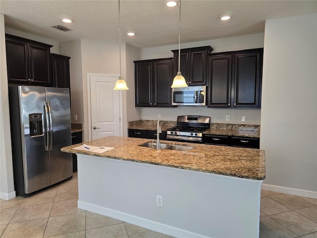 1022 Oliveto Verdi Ct, Brandon, FL 33511 - kitchen with stainless steel appliances, a sink, a center island with sink, light tile patterned flooring, and hanging light fixtures