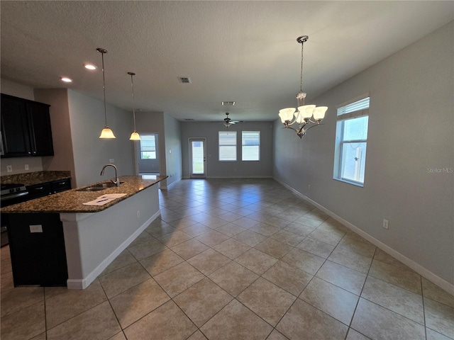 1022 Oliveto Verdi Ct, Brandon, FL 33511 - kitchen featuring a sink, electric range, dark stone counters, baseboards, and a center island with sink