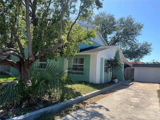 2068 San Marino Way N, Clearwater, FL 33763 - view of side of home with stucco siding, driveway, a garage, and fence