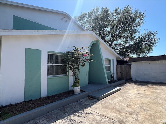 2068 San Marino Way N, Clearwater, FL 33763 - view of side of property with stucco siding, fence, a garage, and driveway