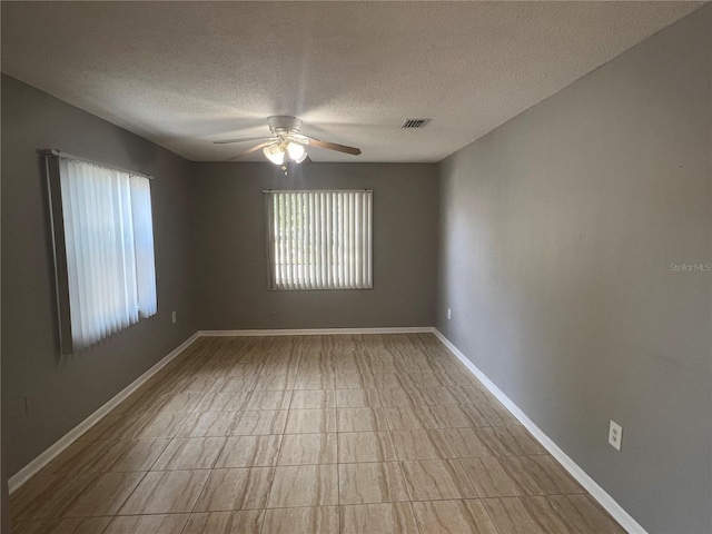 2068 San Marino Way N, Clearwater, FL 33763 - spare room with a textured ceiling, ceiling fan, and baseboards