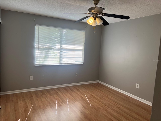 2068 San Marino Way N, Clearwater, FL 33763 - empty room with wood finished floors, a textured ceiling, a ceiling fan, and baseboards
