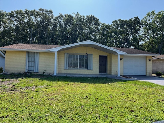 single story home with a garage, brick siding, a front lawn, and driveway
