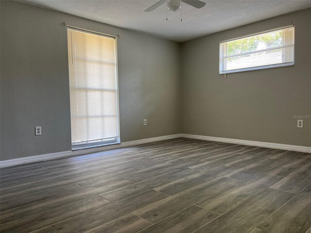unfurnished room featuring ceiling fan, dark wood-style floors, and baseboards
