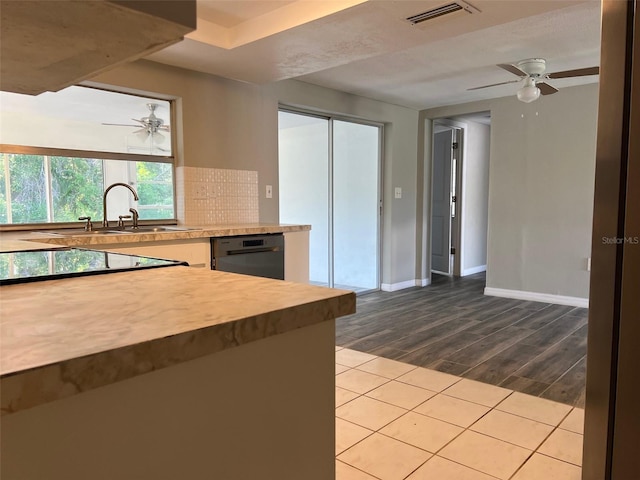 kitchen with a ceiling fan, black appliances, wood finished floors, baseboards, and tasteful backsplash