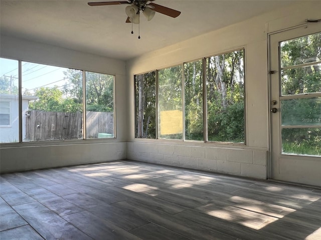 unfurnished sunroom with a ceiling fan and wood finished floors