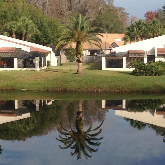 view of home's community featuring a water view and a yard