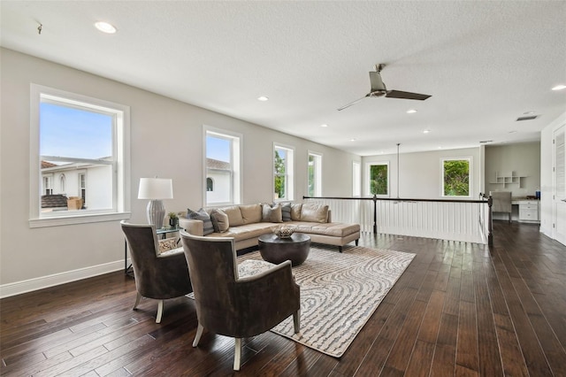 living room featuring a ceiling fan, dark wood finished floors, healthy amount of natural light, recessed lighting, and a textured ceiling