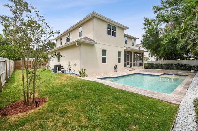 rear view of house with a sunroom, stucco siding, and a patio