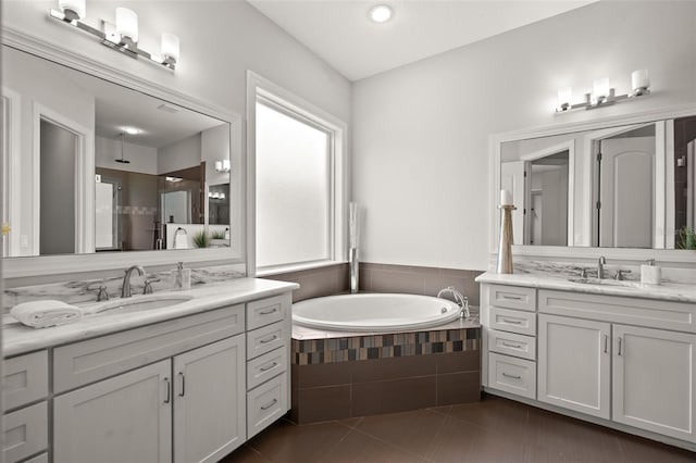 bathroom with tile patterned flooring, a garden tub, two vanities, a shower, and recessed lighting