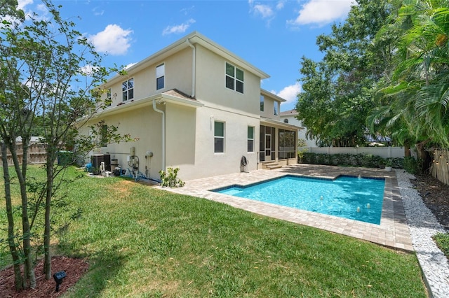 back of property with stucco siding, a sunroom, cooling unit, and a patio area