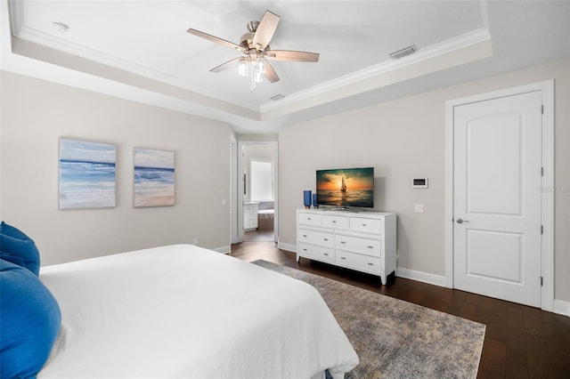 bedroom featuring a raised ceiling, dark wood finished floors, ornamental molding, baseboards, and a ceiling fan
