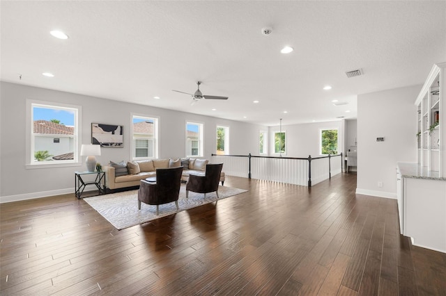 living area with plenty of natural light, recessed lighting, dark wood-style flooring, a ceiling fan, and baseboards