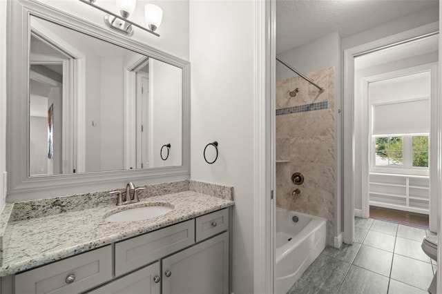 full bath with vanity, tile patterned flooring,  shower combination, and a textured ceiling