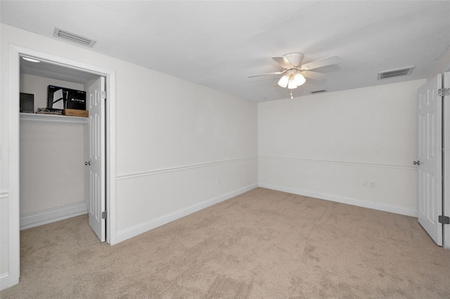 unfurnished bedroom featuring carpet flooring, a spacious closet, a closet, baseboards, and a ceiling fan