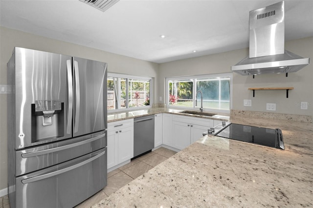 kitchen featuring stainless steel appliances, island exhaust hood, a sink, open shelves, and white cabinetry