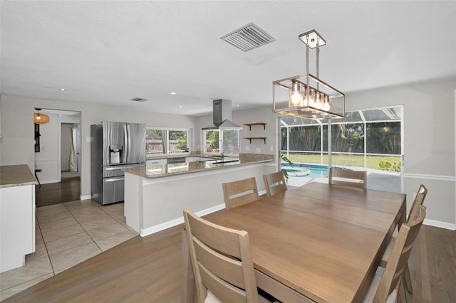 dining room with wood finished floors, baseboards, recessed lighting, and a chandelier